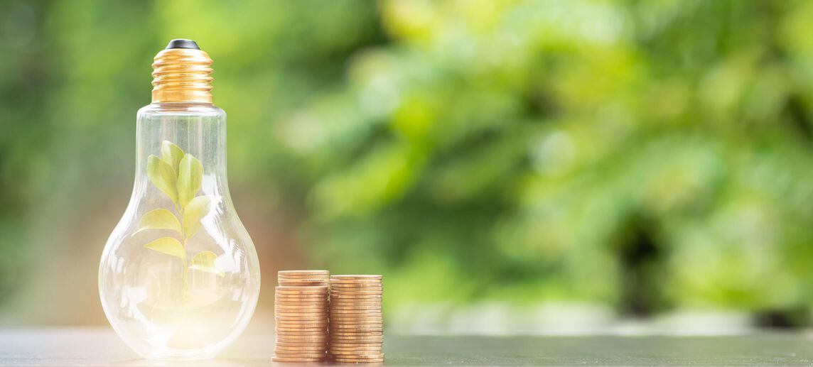 Lightbulb next to stack of change