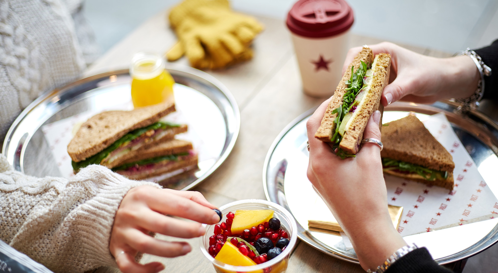 Overhead shot of two people eating lunch in a Pret shop
