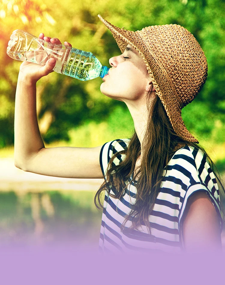Junge Frau trinkt Wasser aus einer Flasche