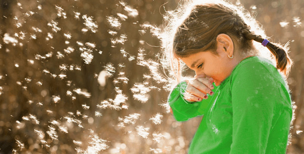 Girl Sneezing With Pollen Floating In The Air