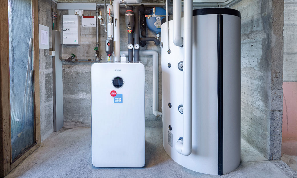 Pompa di calore terra-acqua Bosch CS7800i 12 LW e accumulatore per riscaldamento Oertli SHW 807: eleganza ed efficienza nel locale che accoglieva la vecchia caldaia a gasolio. Pompa di calore terra-acqua Bosch CS7800i 12 LW e accumulatore per riscaldamento Oertli SHW 807: eleganza ed efficienza nel locale che accoglieva la vecchia caldaia a gasolio.