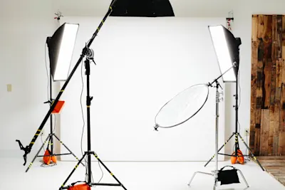 Basics of studio photography 1 Studio with white background, two softboxes on tripods, reflector and cables spread out on the floor.