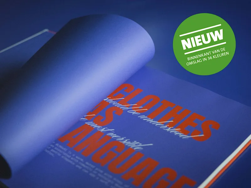 Koffietafelboek Opengeslagen boek met blauwe achtergrond en grote oranje tekst 'CLOTHES IS A LANGUAGE' en een groene sticker met witte tekst 'NIEUW BINNENKANT VAN DE OMSLAG IN 36 KLEUREN' en meer Nederlandse woorden.
