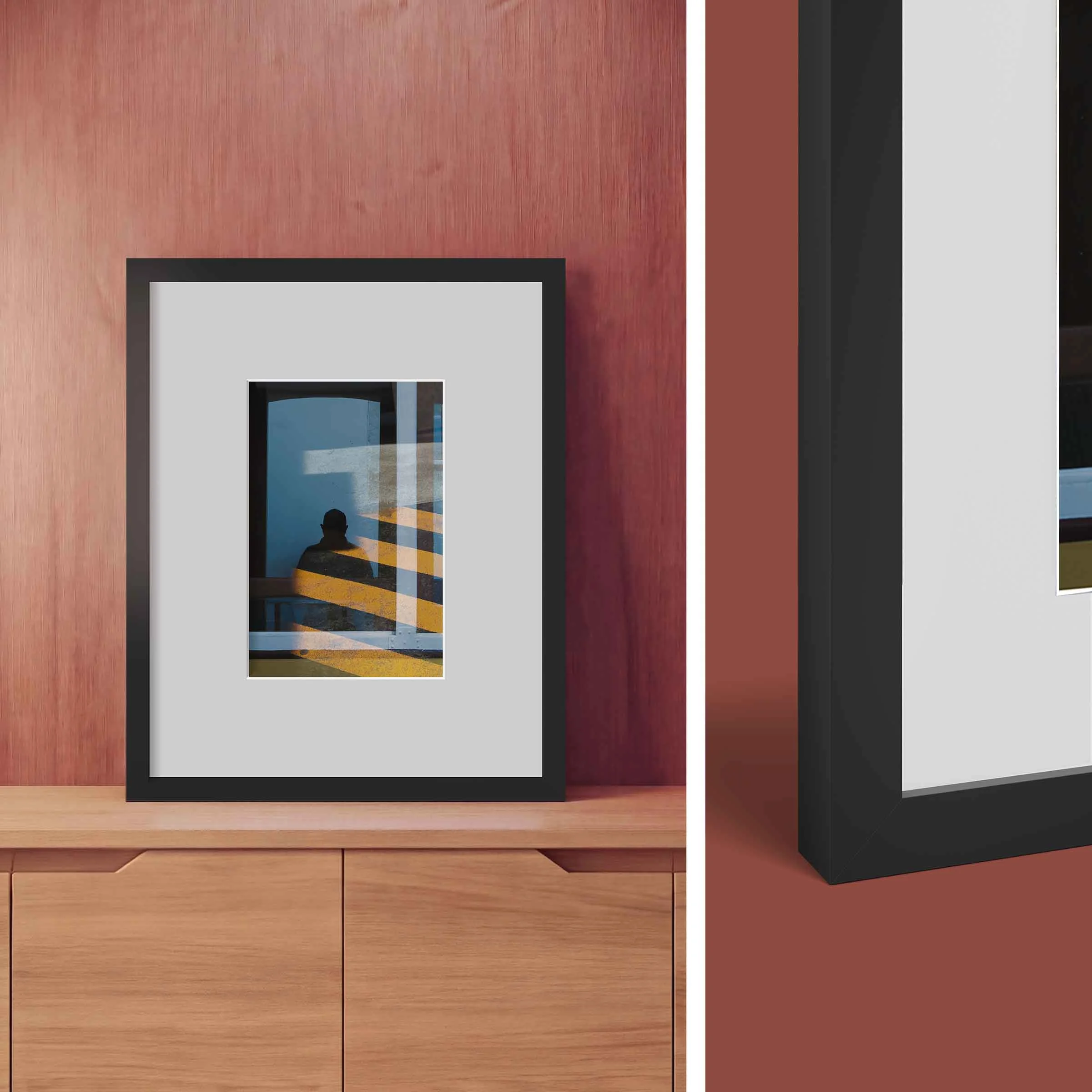 Schwarzer Passepartout-Rahmen Schwarzer Passepartout-Rahmen mit einem Foto, das eine Person vor einem Fenster mit Licht- und Schattenmustern zeigt.