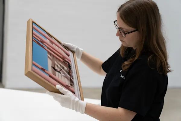 expert from our manufacture examining a framed artwork expert from our manufacture wearing white gloves carefully examines a framed artwork.