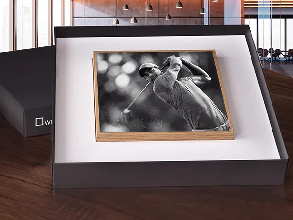 Artbox Gift Edition Black and white framed photograph of a golfer mid-swing displayed in an open presentation box on a wooden surface