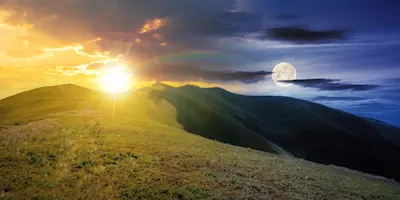 Introduction au traitement des images 4 Paysage vallonné avec le soleil à gauche à l'horizon et la pleine lune à droite dans le ciel par temps clair.