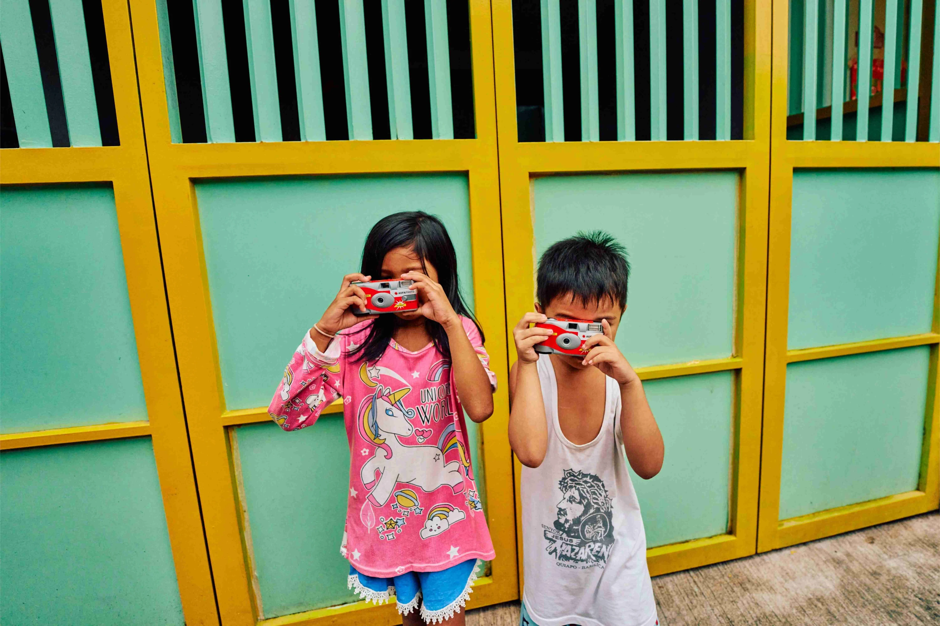 Two kids taking photos