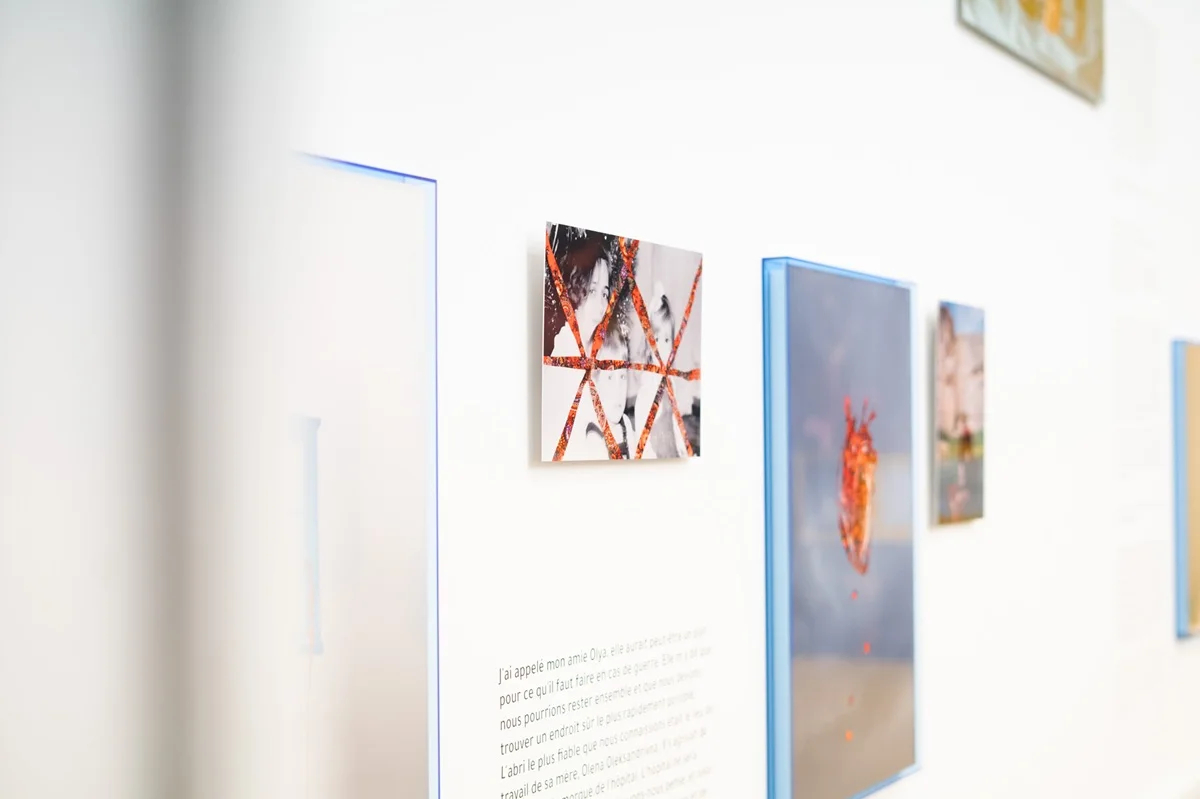 Maryna Brodovska Focus Ukraine - Festival Circulations Kunstgalerie-Wand mit abstrakten Bildern mit roten geometrischen Mustern in neonblauen Rahmen und Texttafeln