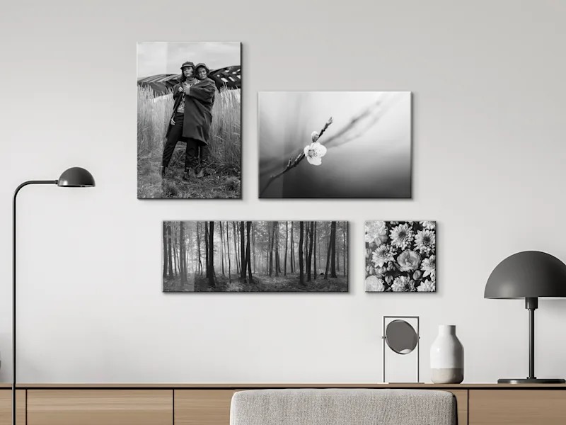 Four black-and-white acrylic glass photographs Four black-and-white acrylic glass photographs on a white wall above a sideboard.
