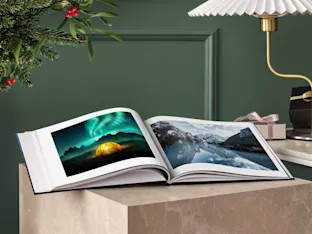 Coffee Table Book whitewall coffee table book with winter motifs lying opened on a table.