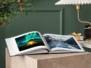 Coffee Table Book whitewall coffee table book with winter motifs lying opened on a table.