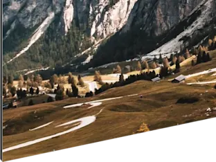 Foto afdruk op Aluminium Dibond Fotoafdruk van een landschap met een kronkelend pad door een weide, omringd door bomen en bergen op de achtergrond.