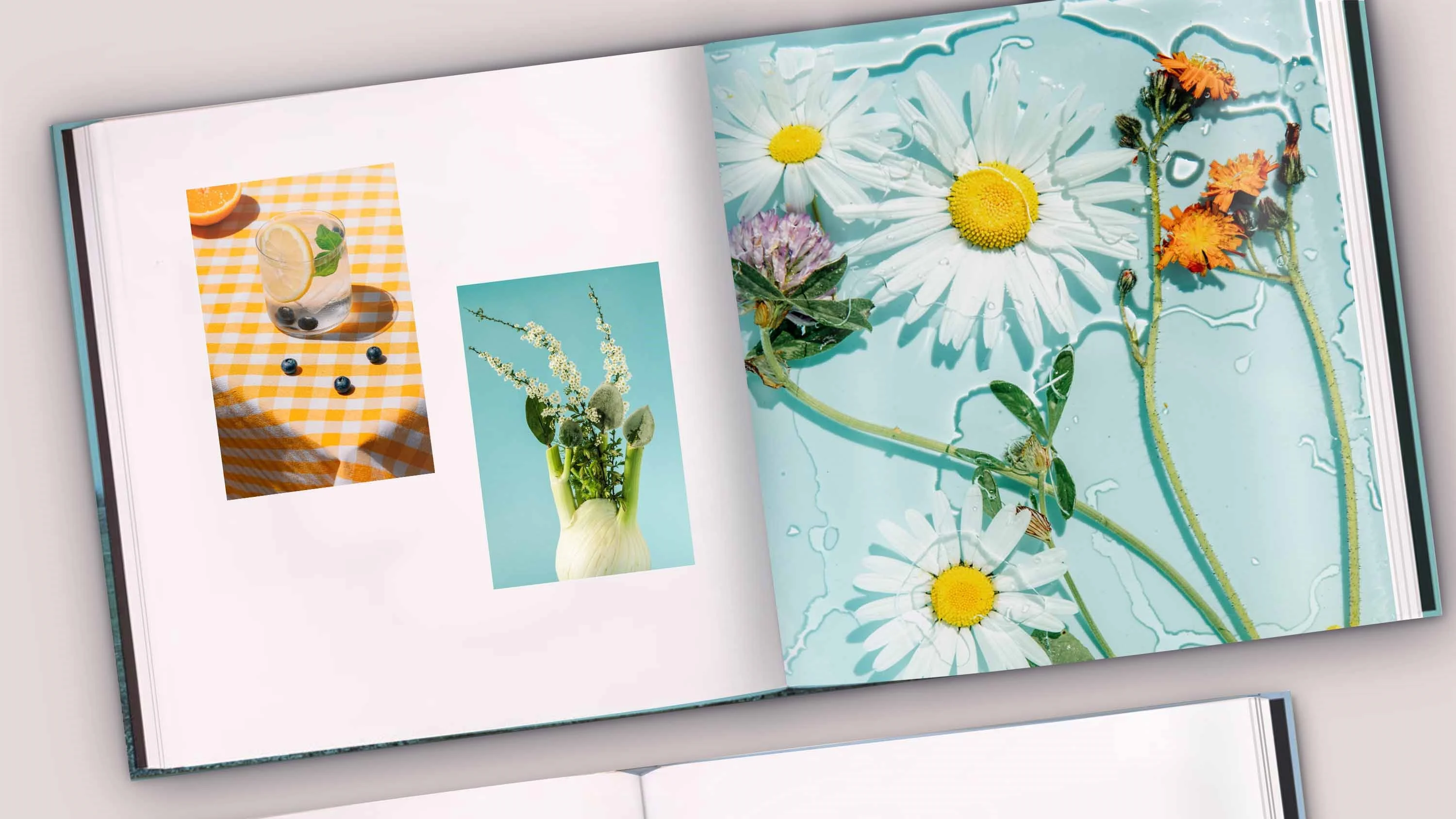 An open Coffee Table Book with a double-page spread showing a woman in a long yellow dress on the left and a close-up of a face with yellow flowers in the foreground on the right.