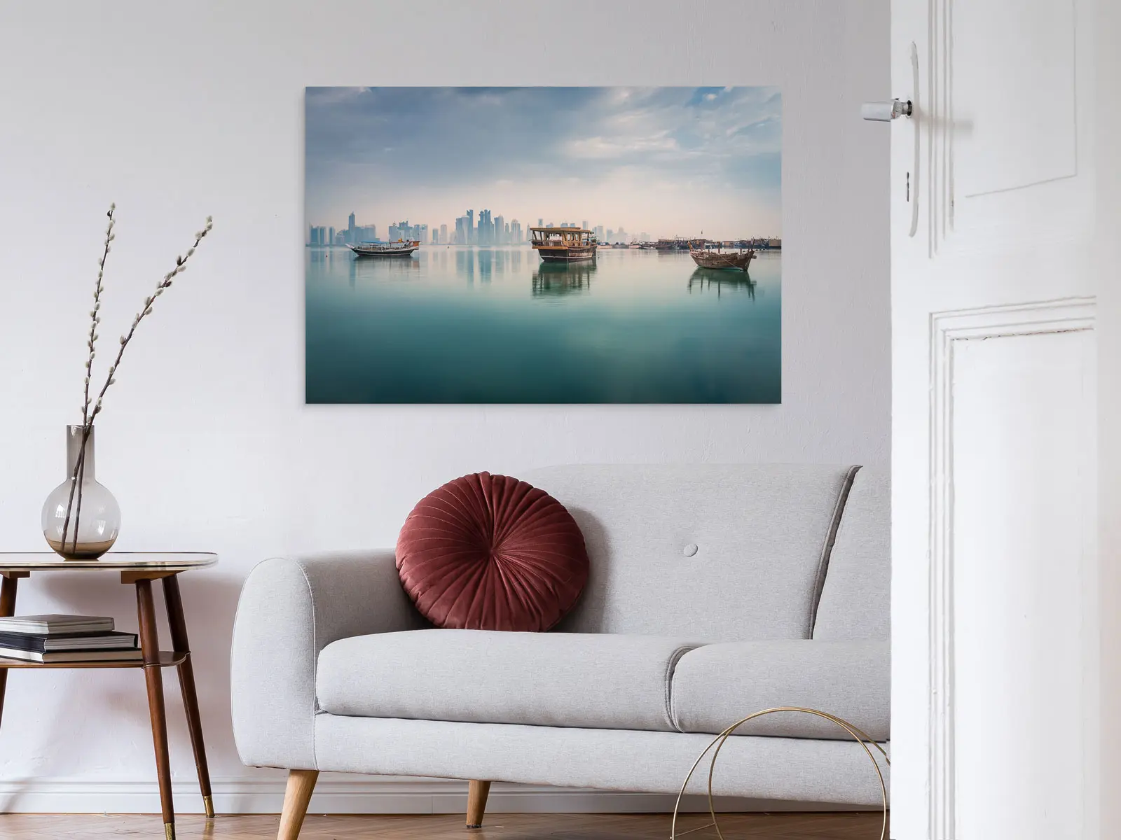 Three boats reflected on the calm sea surface, while in the background is a skyline on a Photo Print On Aluminum Backing hangs on a wall in a living room.