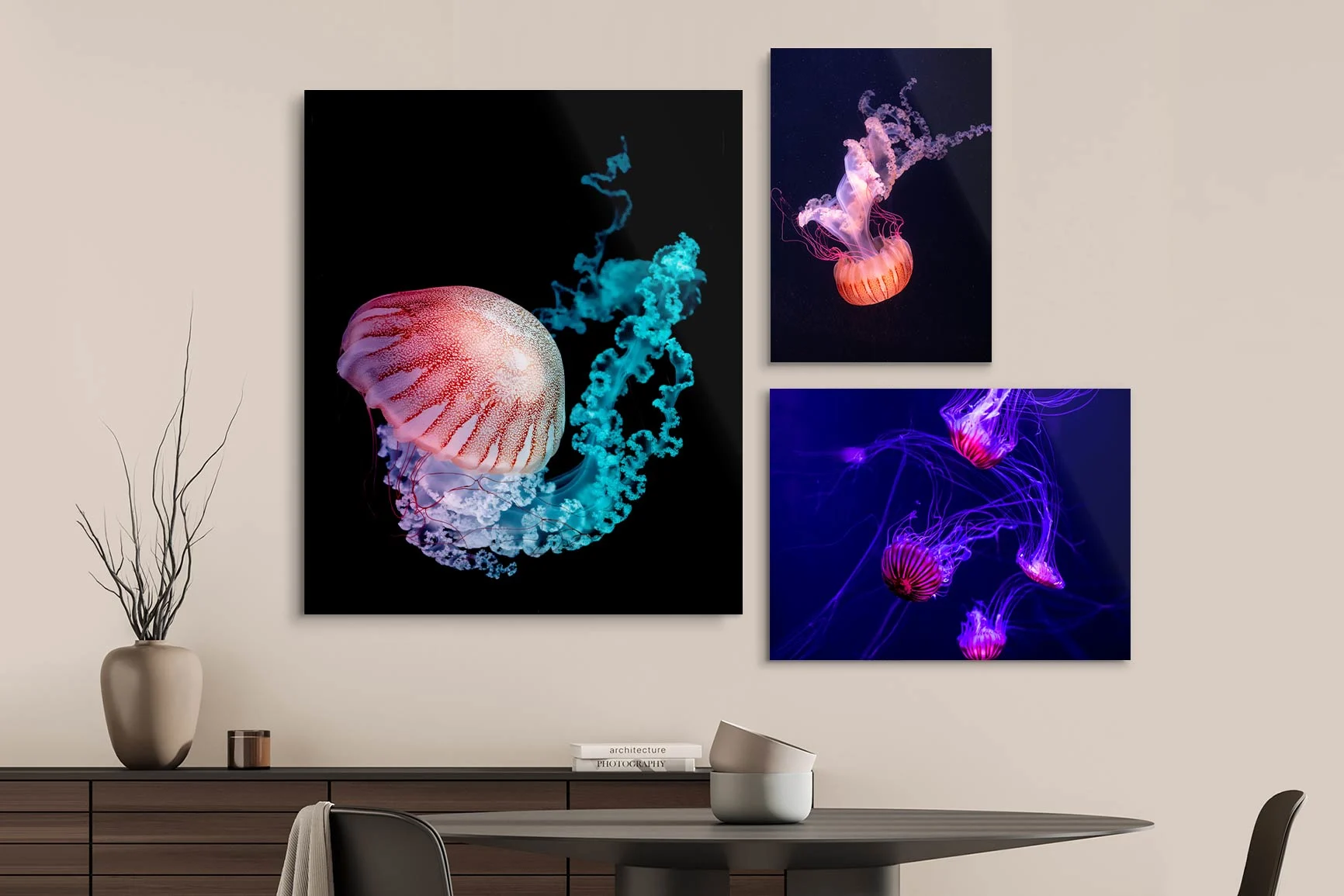 Tres cuadros con medusas luminosas de diferentes colores y formas sobre una mesa de comedor. Tres cuadros con medusas luminosas de diferentes colores y formas sobre una mesa de comedor.