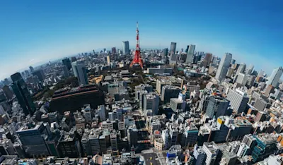 Weitwinkelobjektiv Weitwinkelaufnahme einer Stadt mit Tokio Tower im Zentrum, umgeben von Hochhäusern.