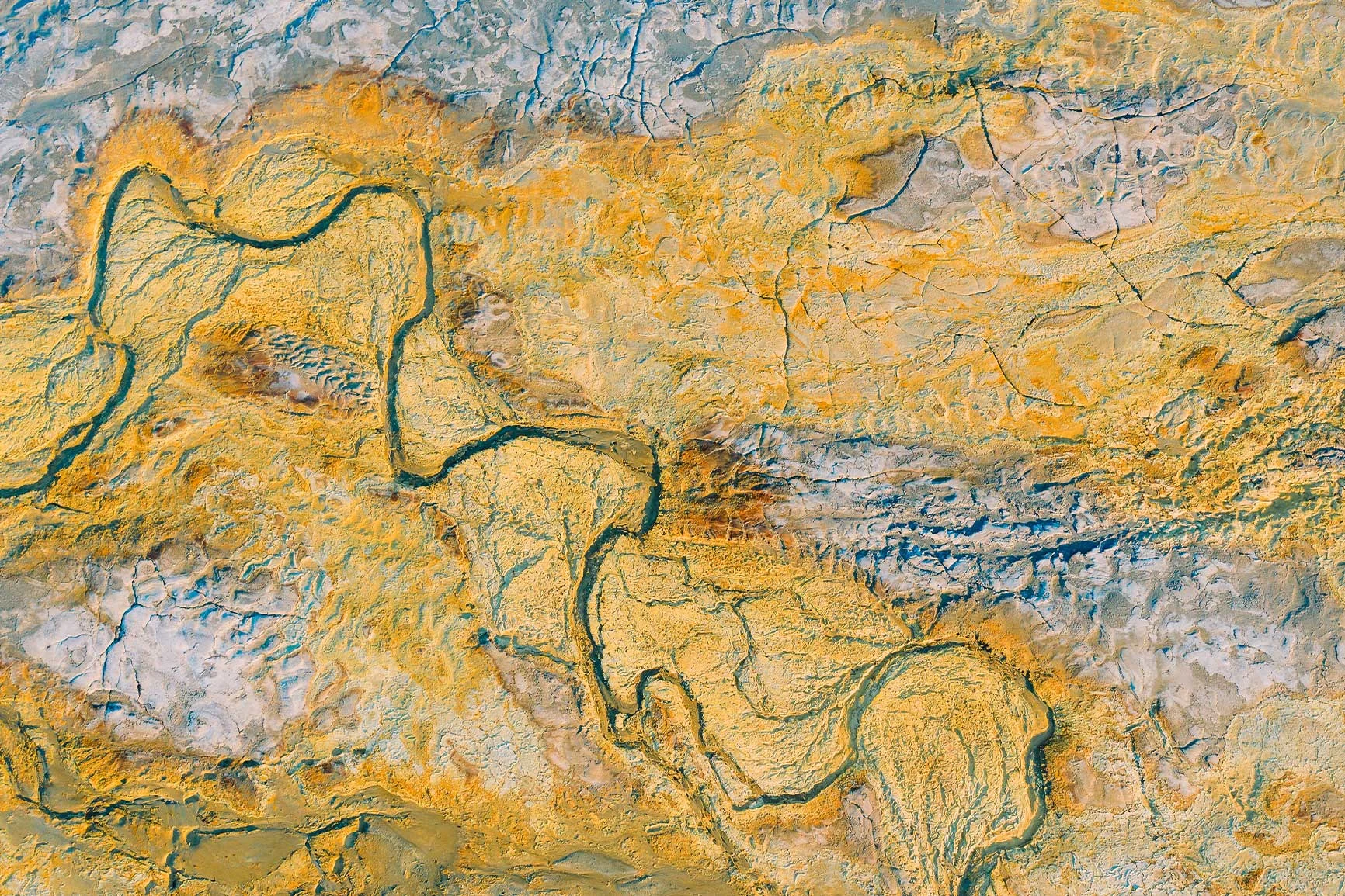 Aerial view of a river course Aerial view of a meandering river winding through a sandy landscape that is partly devoid of vegetation.
