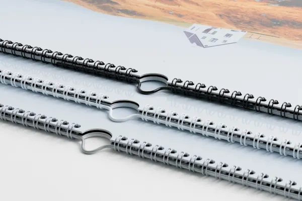 Calendario Fotografico di Alta Qualità Tre quaderni a spirale con anelli metallici disposti in diagonale su una superficie bianca