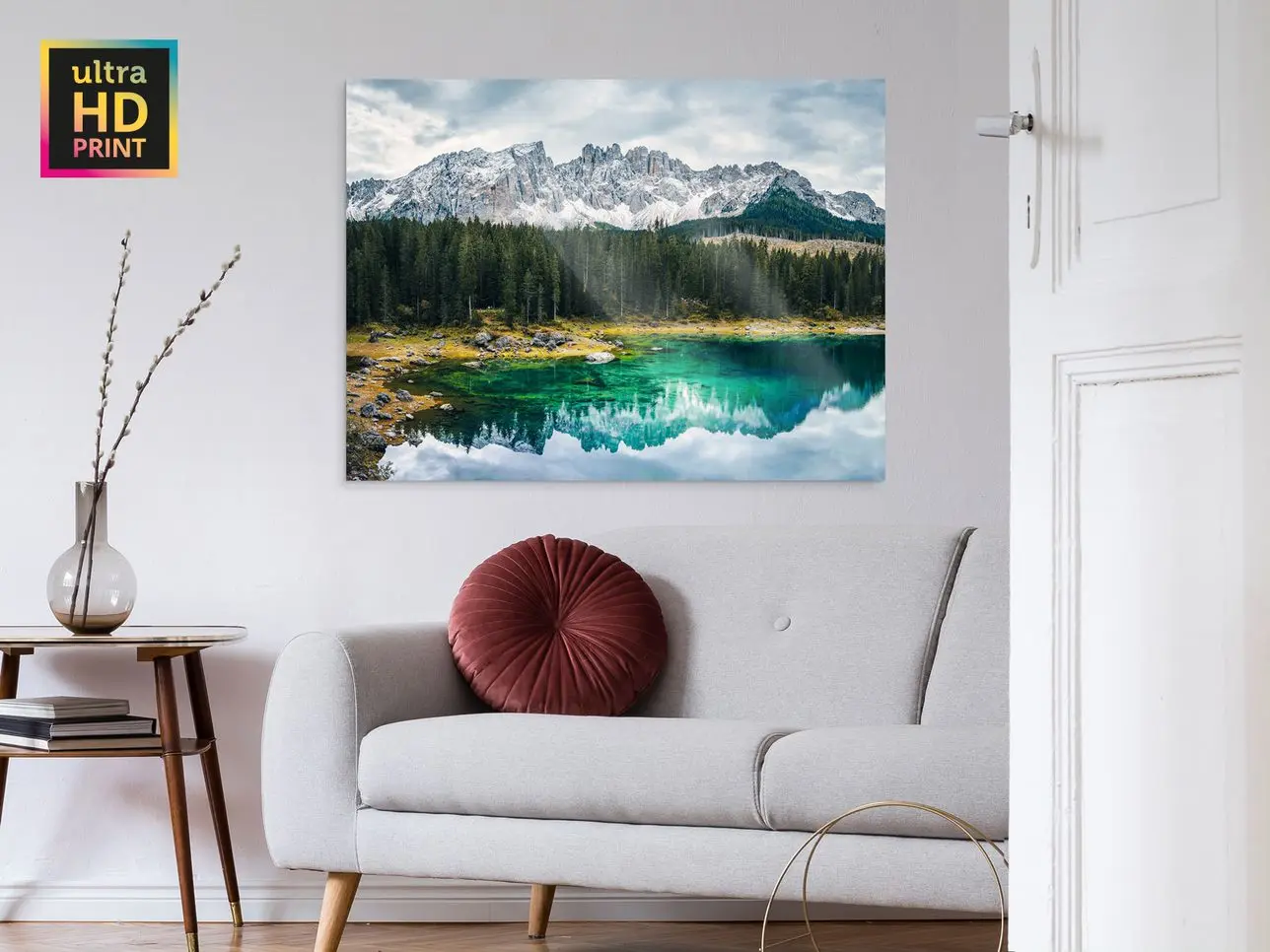 A mountain and a forest reflected in a lake on a ultraHD Photo Print On Aluminum Backing hangs on a wall in a living room.
