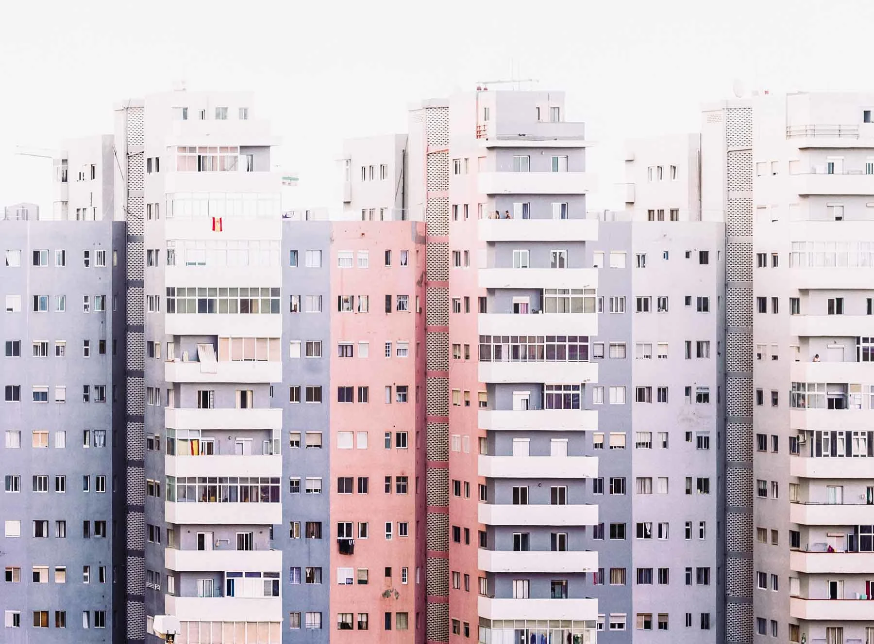 Varios edificios residenciales altos con balcones y ventanas, en diferentes colores claros. Varios edificios residenciales altos con balcones y ventanas, en diferentes colores claros.