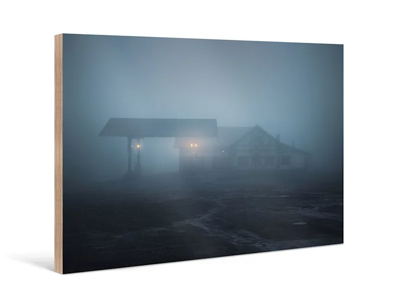 Foto-Abzug auf Holz Auf einem Foto-Abzug auf Holz ist eine Hütte im Nebel zu erkennen.