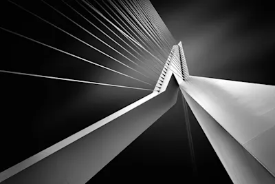 Black-and-white photo of a suspension bridge A black-and-white photograph of a modern suspension bridge taken from a low angle, with the suspension cables visible.