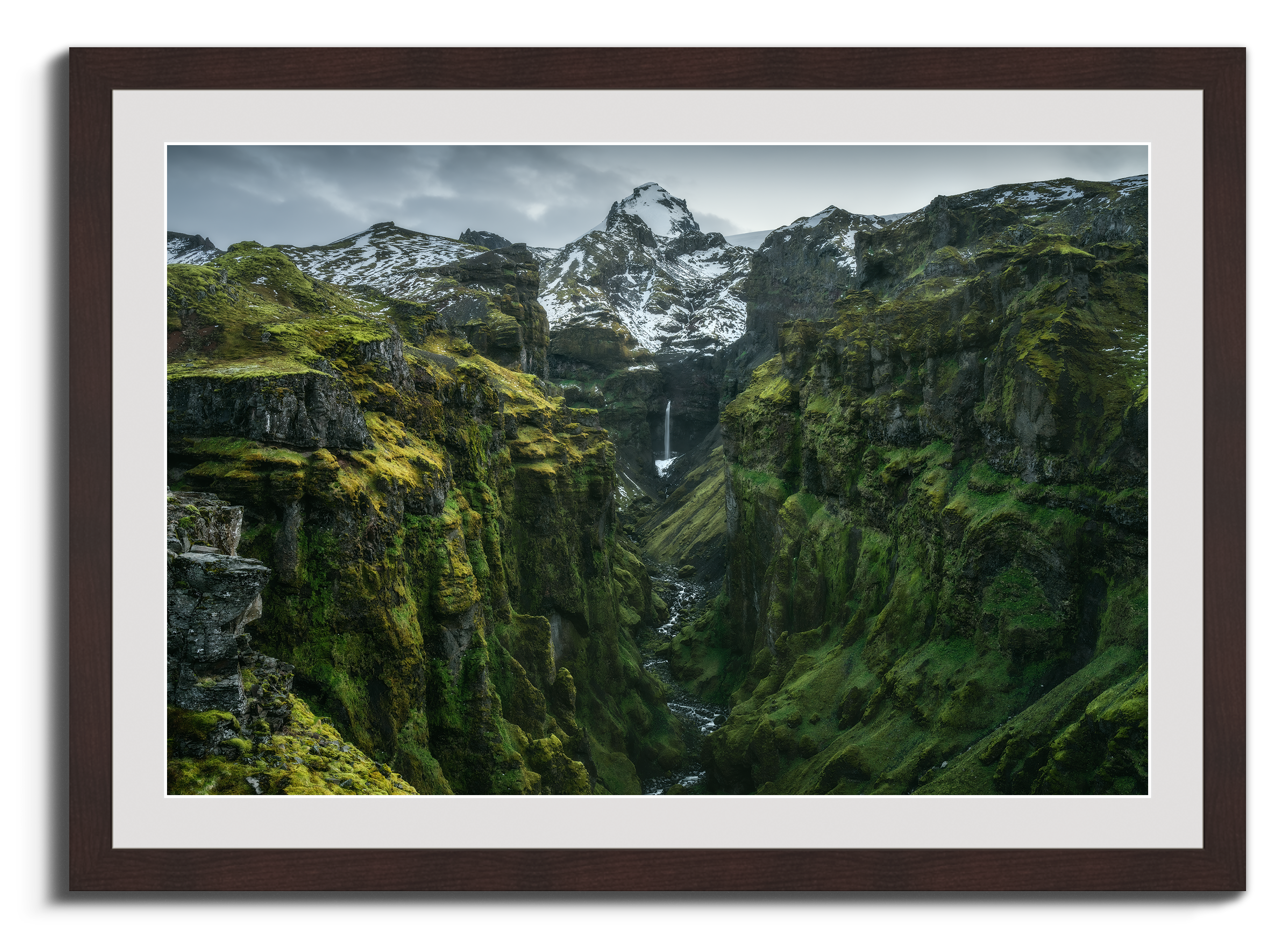A picture of green Iceland in a wooden passepartout frame.