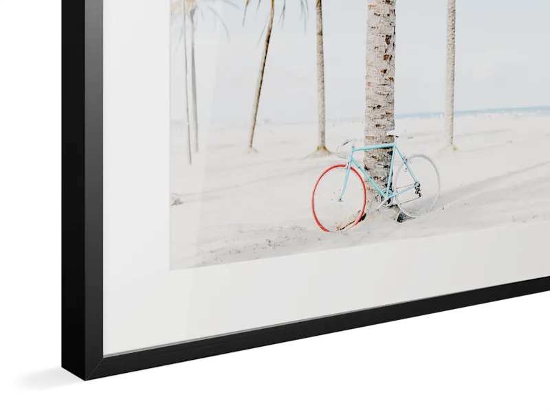 Close-up of black Magnet Frame with light blue vintage bicycle with red wheel leaning against birch trees in snowy winter landscape.