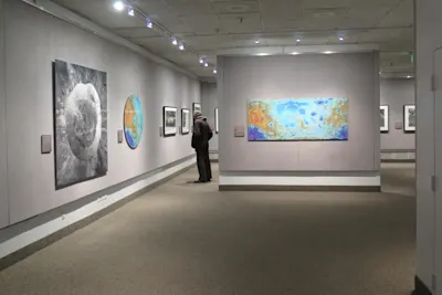 Mark Robinson - Bilder vom Mond Person betrachtet Mondbilder in einer Mondbild-Galerie mit beleuchteten Wänden