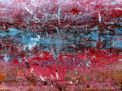Oberflächenfotografie Abgenutzte, zerkratzte Oberfläche mit roter, blauer und brauner Textur, zeigt Patina und Verwitterung.