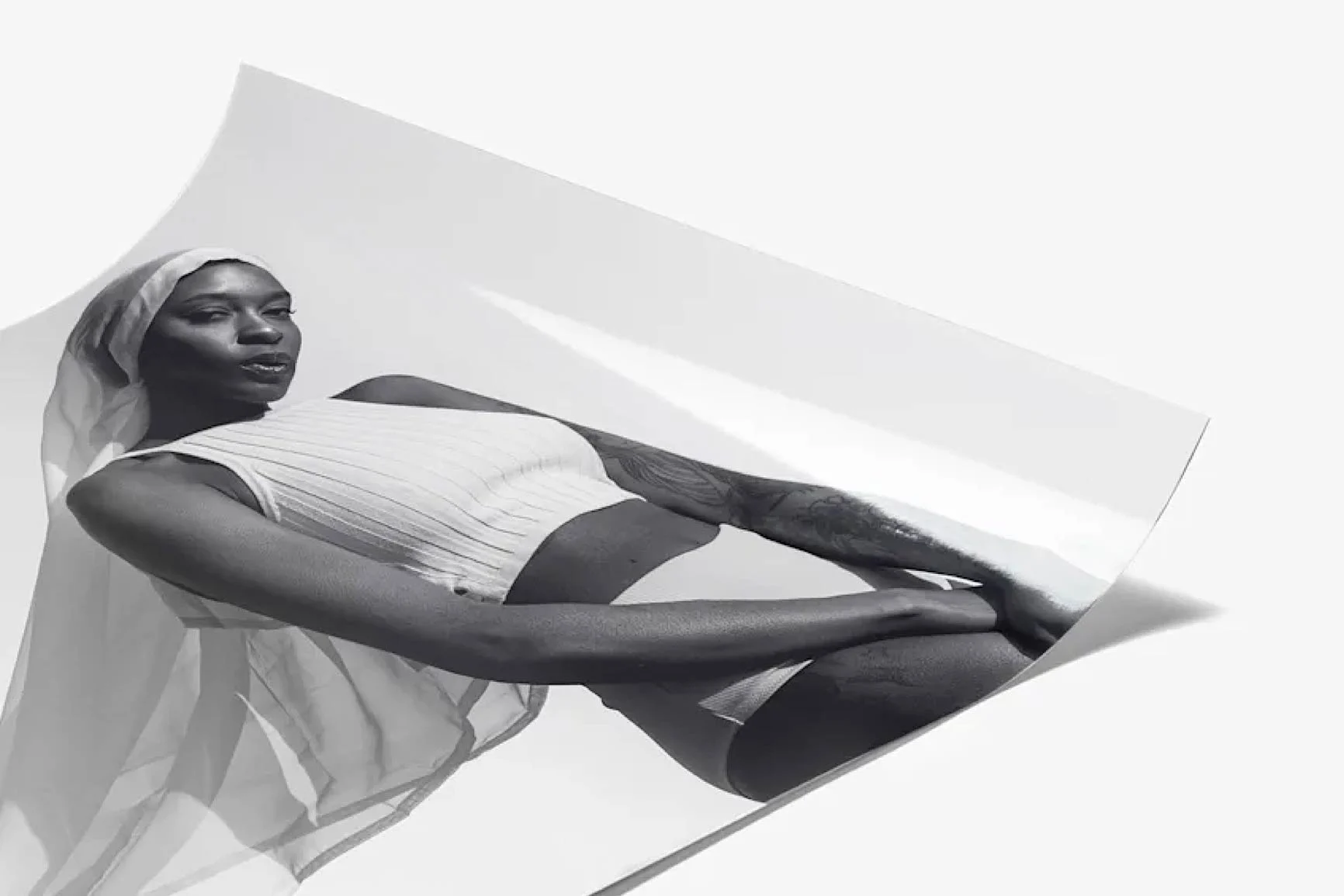 Black-and-white photograph of a woman A black-and-white photograph of a woman with her head covered, wearing a white top and bottom.