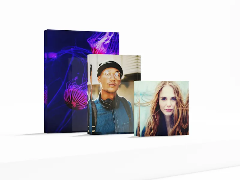 Foto-Acrylblock Drei Foto-Acrylblöcke in unterschiedlichen Größen, mit je einem Motiv: leuchtende Quallen, Person mit Kopfhörern, Frau mit langen Haaren.