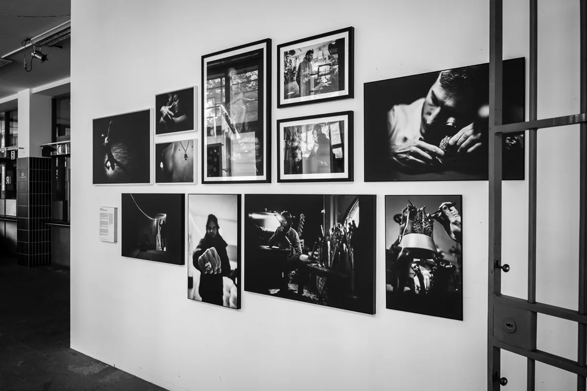 Phil Penman, Biel Fotogalerie mit schwarz-weißen Fotografien in einem Rastermuster an einer weißen Wand, die verschiedene künstlerische Porträts und Szenen zeigt