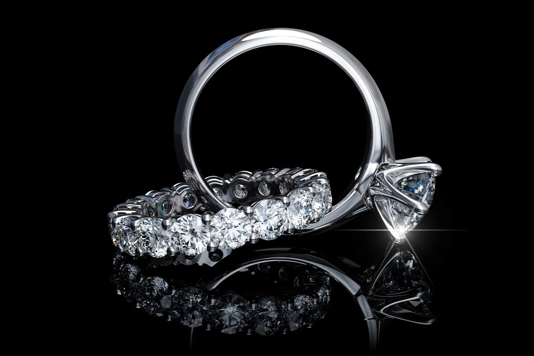 Anelli d'argento con diamanti Due anelli d'argento con diversi diamanti rotondi: uno è un anello solitario con un grande diamante, l'altro presenta una fila continua di diamanti.