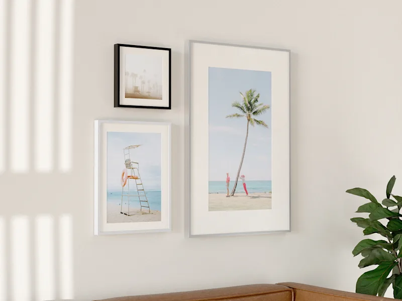 Magneet wissellijst Muur met drie ingelijste foto's eraan. Twee foto's met een passe-partout. De foto's zijn ingelijst met aluminium lijsten.