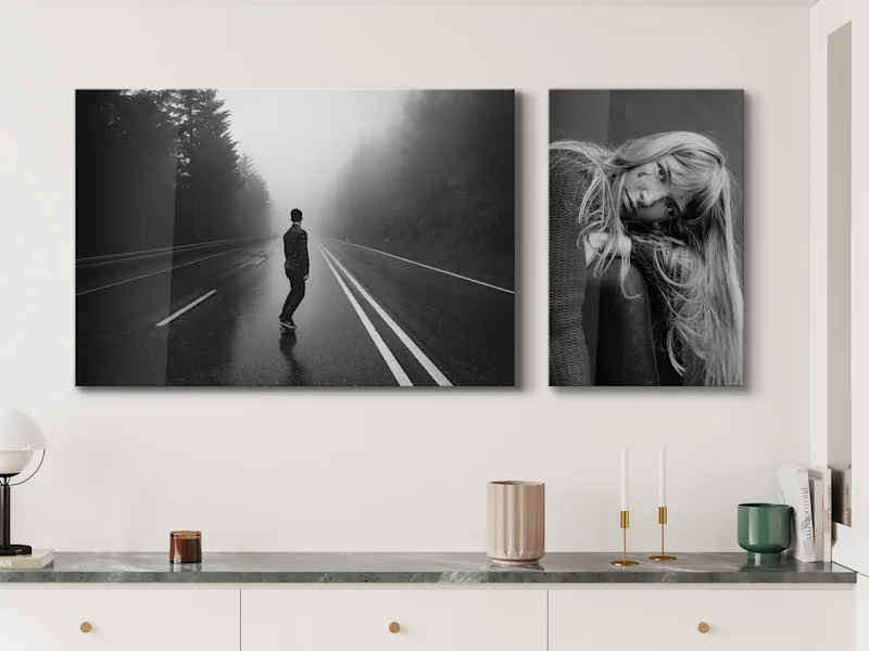 Two black-and-white photos on the wall Two black-and-white photos on a wall: on the left, a person on the street; on the right, a portrait of a woman.