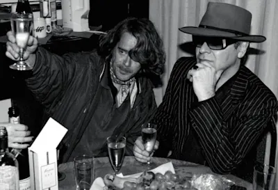 Michael von Gimbut – Udo Lindenberg Udo Lindenberg (rechts) und ein Mann stoßen mit Sekt an.