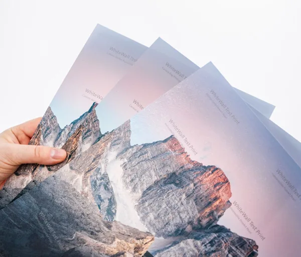 Close-up of test prints on various fine art papers Three different fine art papers with the test print watermark are held in a hand