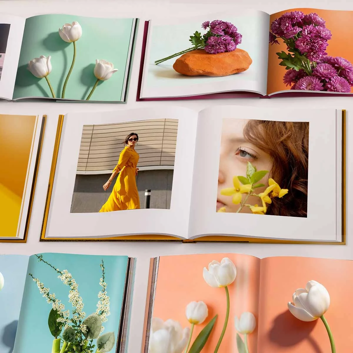 A Coffee Table Book laid flat An open Coffee Table Book with a double-page spread showing a woman in a long yellow dress on the left and a close-up of a face with yellow flowers in the foreground on the right.