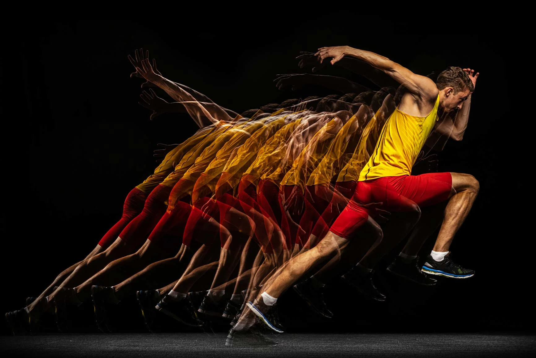 Sprinter in yellow jersey and red pants shown several times, movement sequence on black background. Sprinter in yellow jersey and red pants shown several times, movement sequence on black background.