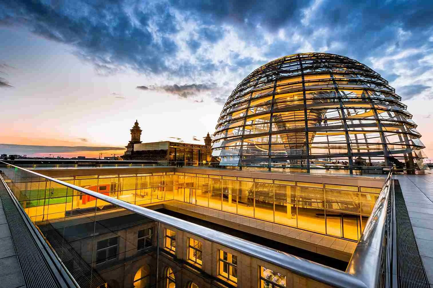 The Reichstag dome in Berlin The illuminated glass dome of the Reichstag in Berlin at sunset, with a view across the rooftop terrace.