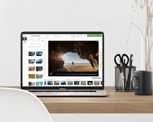 Calendario Fotografico Online Un laptop su cui viene modificato un calendario nel configuratore è posizionato su un tavolo.