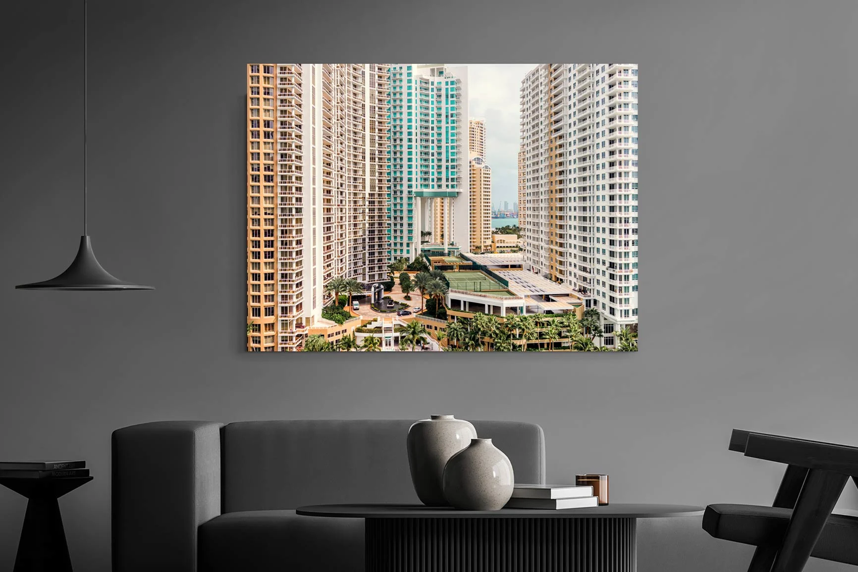 Quadro in alluminio Dibond con grattacieli in una città, appeso sopra un divano grigio in un soggiorno moderno. Quadro in alluminio Dibond con grattacieli in una città, appeso sopra un divano grigio in un soggiorno moderno.