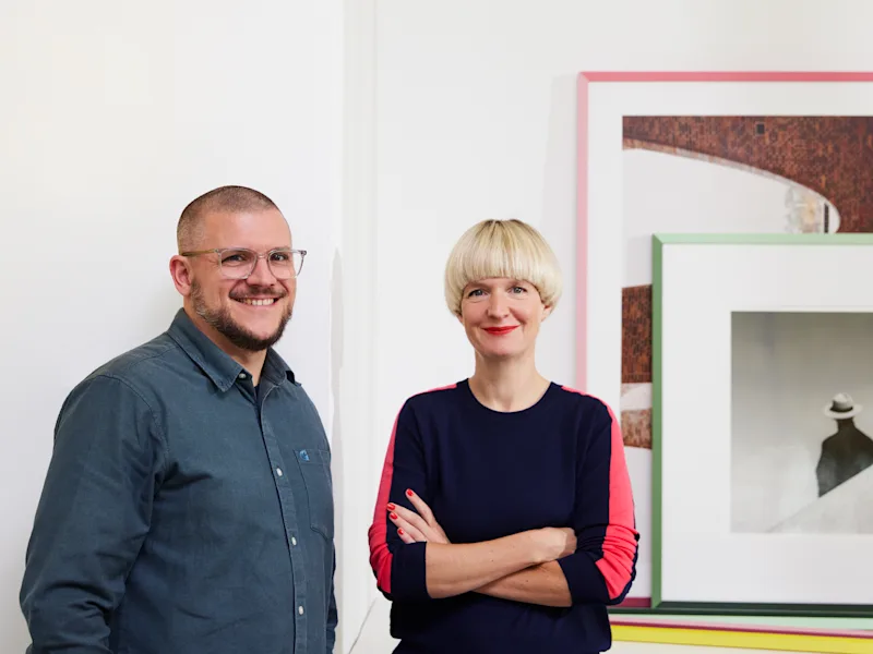Frame: WhiteWall Design Edition by Studio Besau-Marguerre Image of the designers Eva Marguerre and Marcel Besau, standing next to each other.