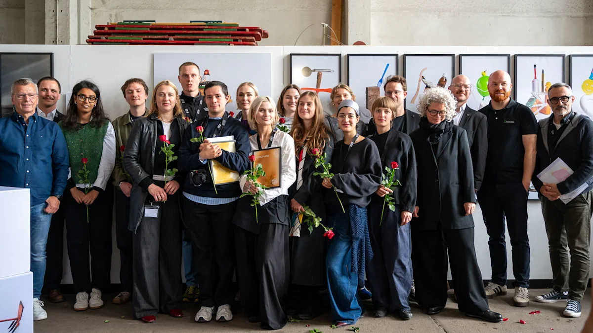 WhiteWall x BFF Award with Finalists A large group of people posing together at an art event, several holding red roses and awards, with framed artwork displayed behind them.