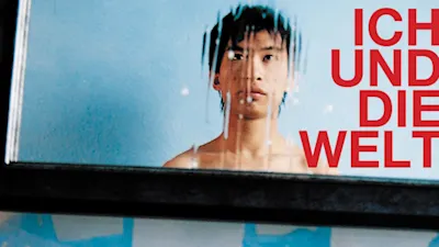 Plakat deutscher Jugendfotopreis Spiegelung eines jungen Mannes mit nassem Glas, daneben roter Text.
