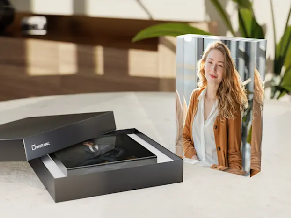 Acryl-Fotoblock Professioneller Fotoabzug und schwarze Präsentationsbox auf weißer Marmoroberfläche mit Innenbeleuchtung dargestellt