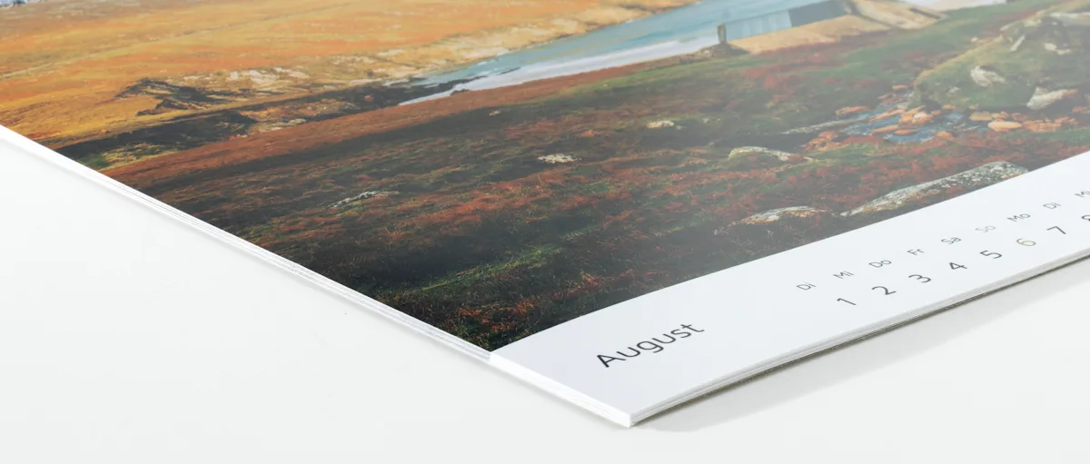Fotokalender Fotopapier seidenmatt Kalenderseiten aufgefächert mit Luftaufnahmen von herbstlich gefärbter Landschaft mit Flüssen und Bergen