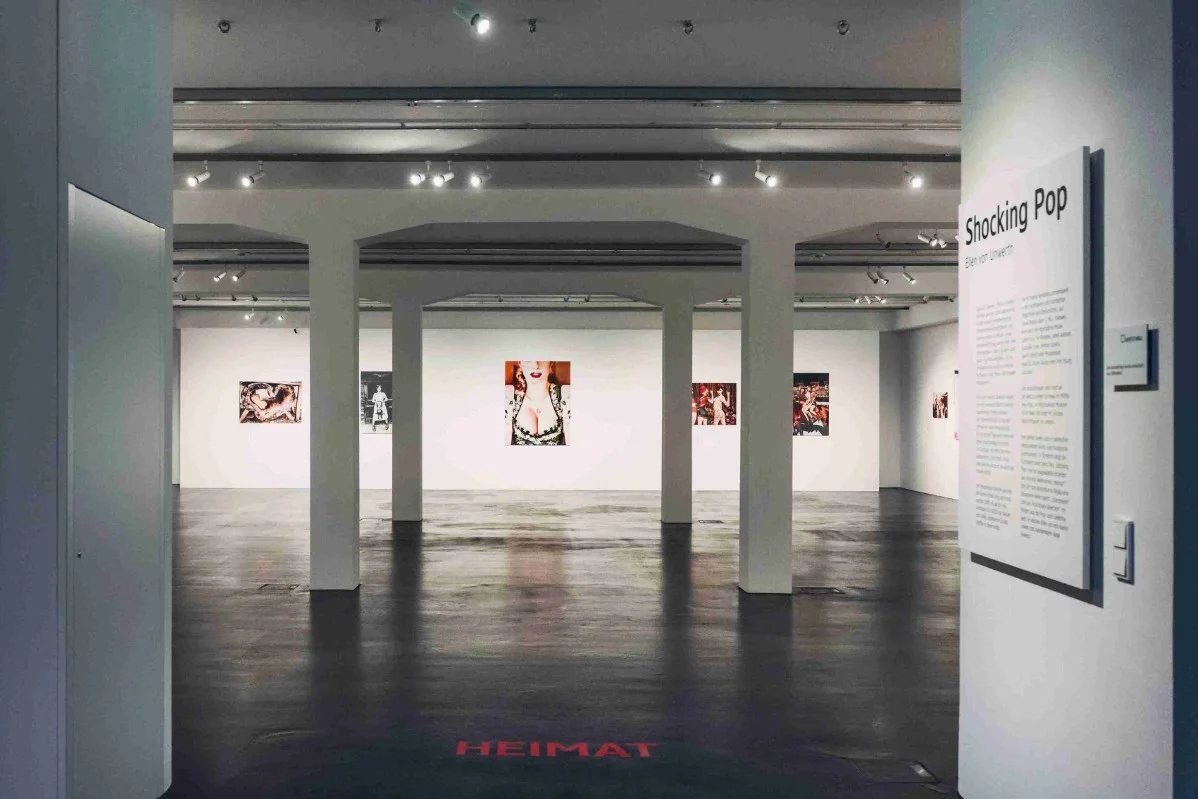 Vue de la galerie « Shocking Pop » avec plusieurs œuvres d'art accrochées aux murs et une rangée de colonnes dans la pièce.